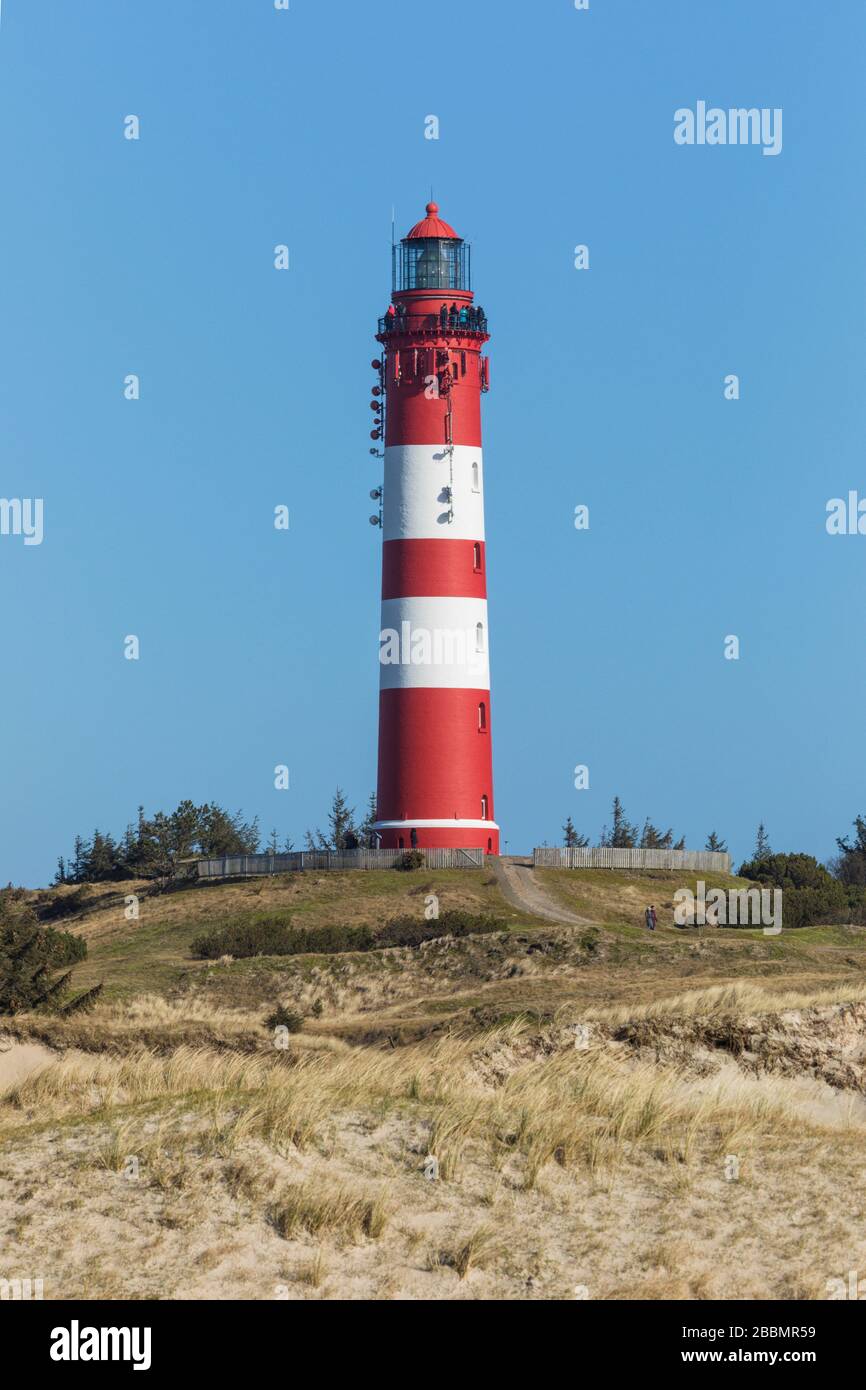 Touristen, die den Leuchtturm von Amrum besuchen. Es ist das bekannteste Wahrzeichen der Insel. Stockfoto