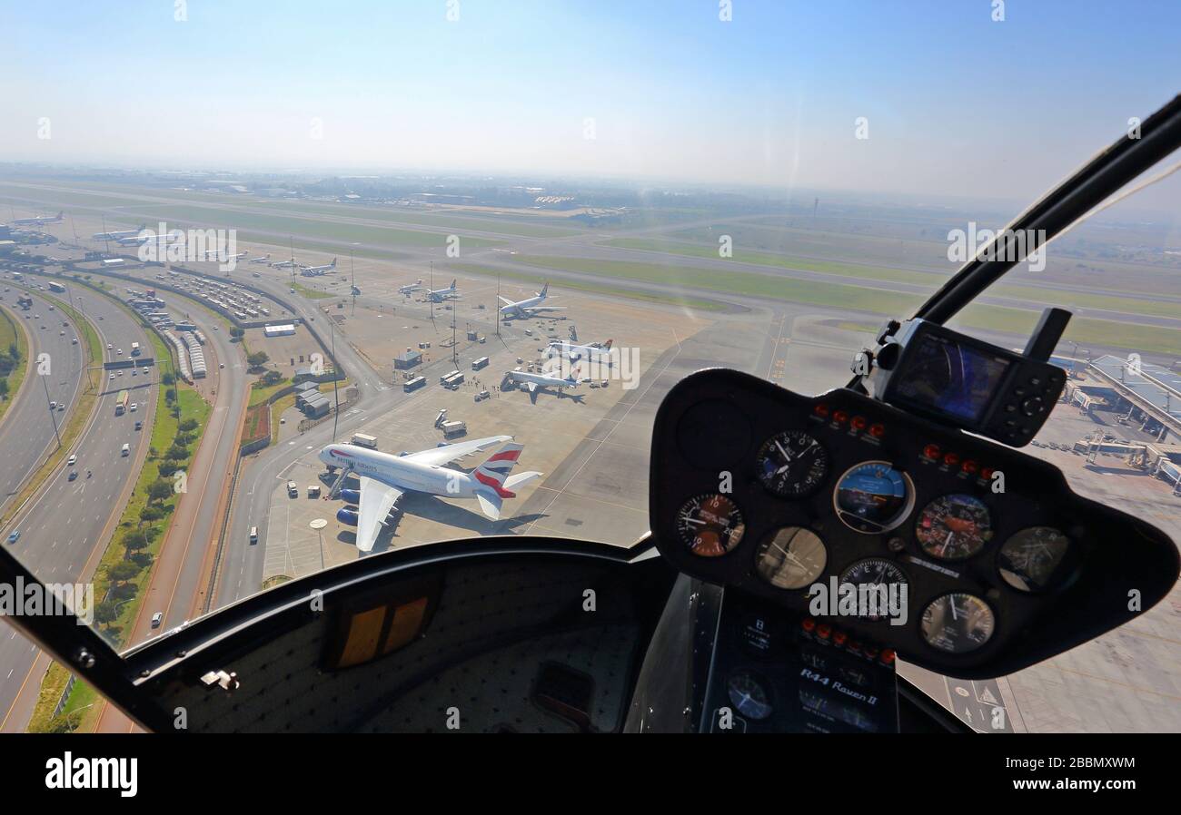 Hubschrauber fliegt über ODER Tambo International Airport und British Airways A380 Stockfoto