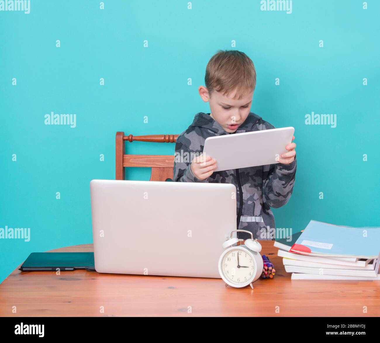 Schulkind mit Laptop während der Schularbeiten zu Hause. Homeschooling. Schule von zu Hause. Stockfoto