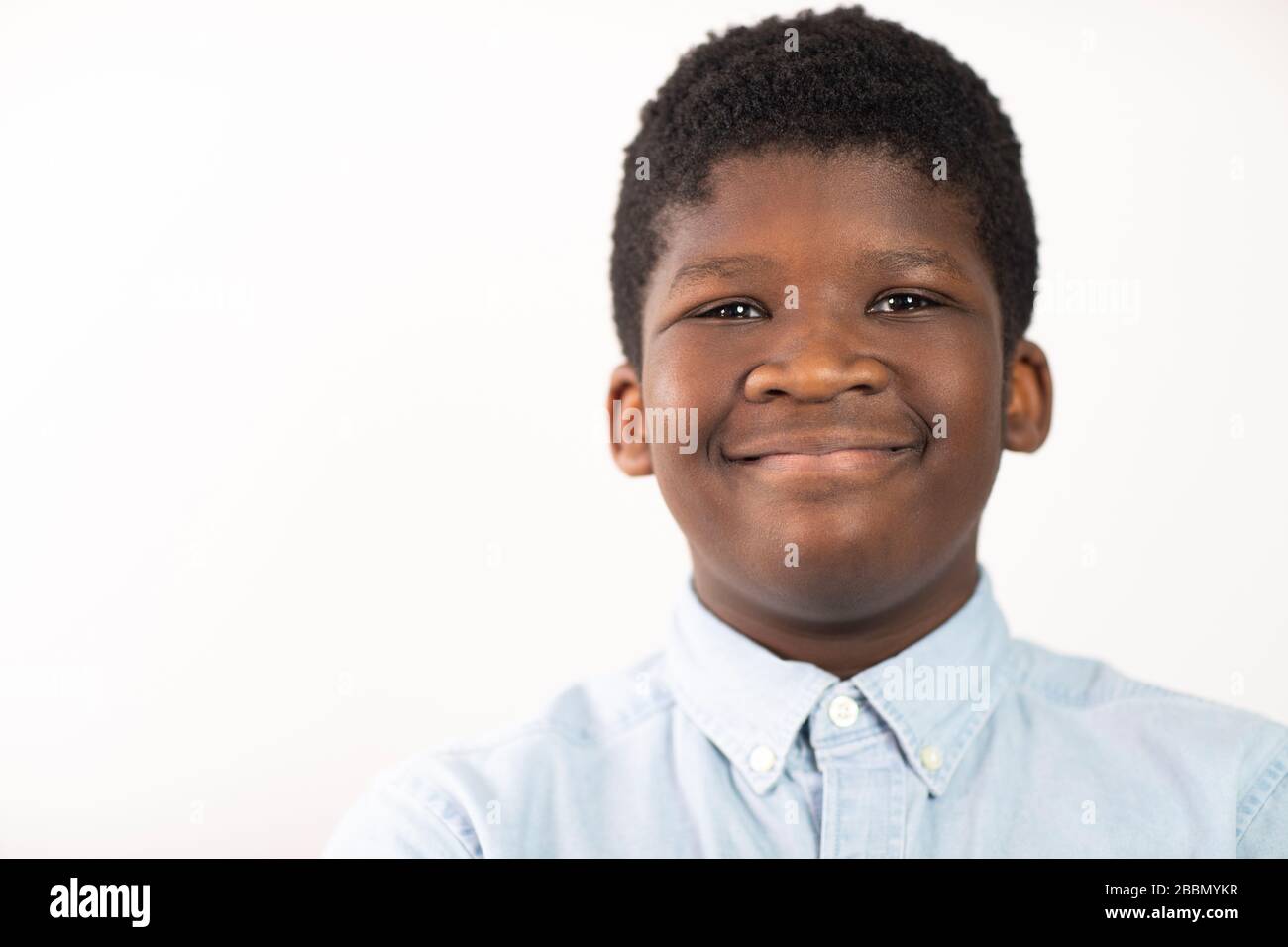 Head and Shoulders Studio Portrait of Smiling Boy vor weißem Hintergrund Stockfoto