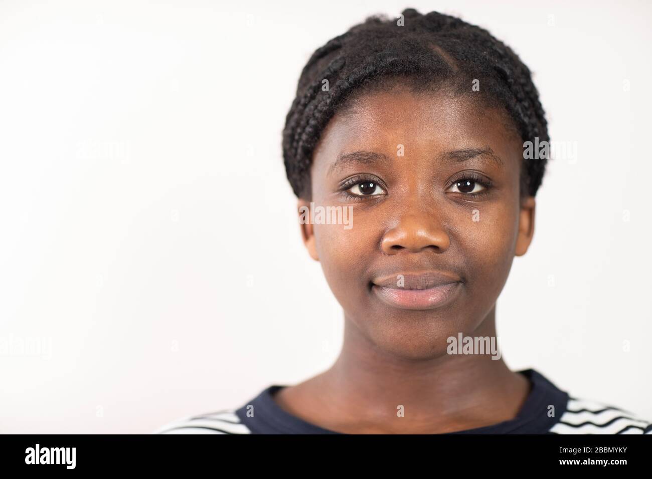 Head and Shoulders Studio Portrait of Smiling Teenage Girl vor weißem Hintergrund Stockfoto
