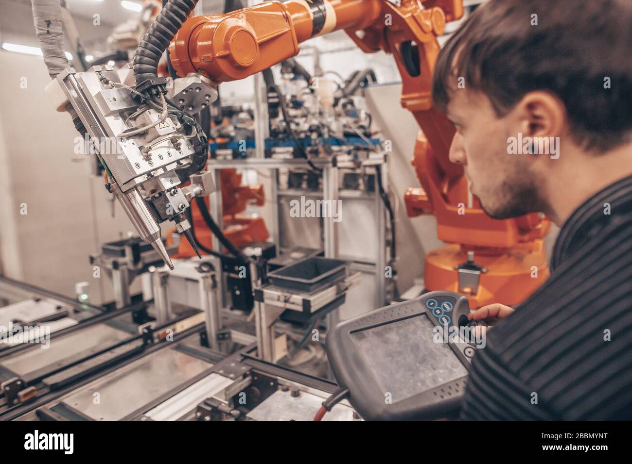 Ingenieur, Techniker, der mit automatischen Robotern in der Automobilindustrie arbeitet, intelligente Fabrik, automatisierter Arbeitsplatz Stockfoto