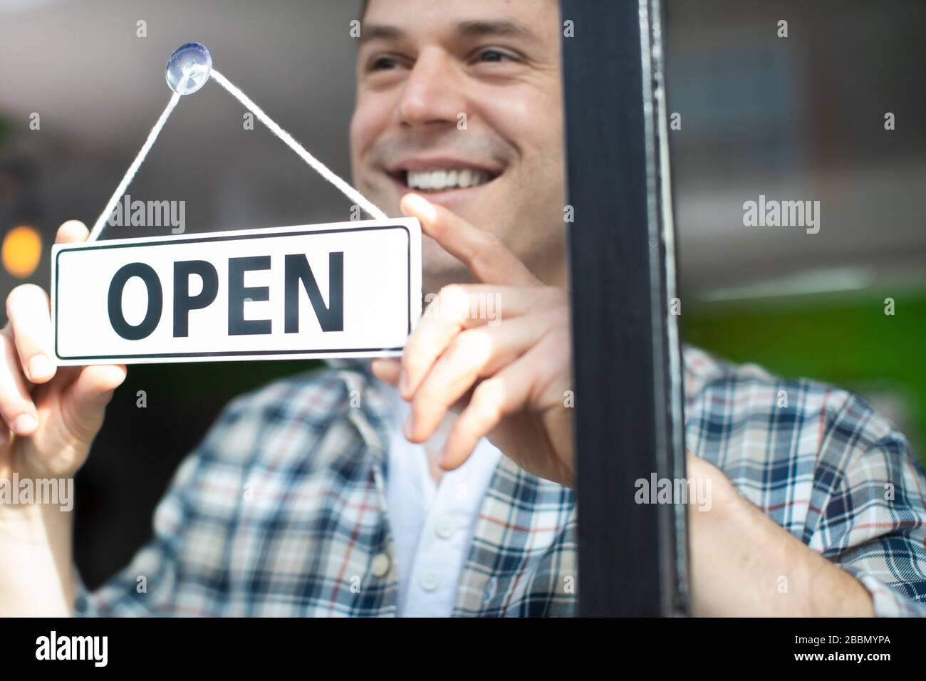 Smiling Small Business Owner Dreht Sich Um Open Sign On Shop Oder Store Window Oder Door Stockfoto