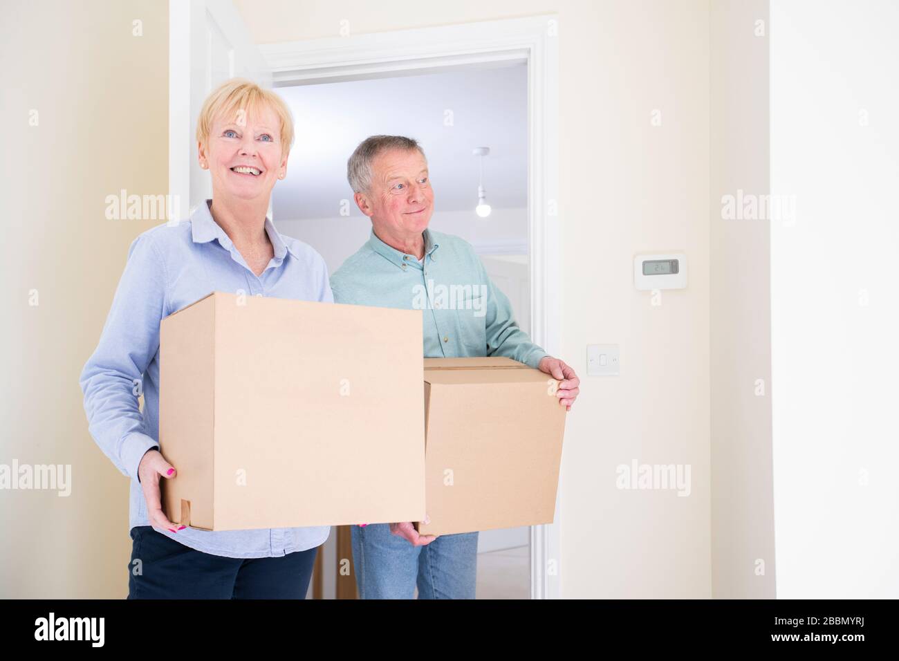Senioren-Paar Schrumpft In Der Altersvorsorge Und Transportiert Boxen Am Umzugstag In Die Neue Heimat Stockfoto