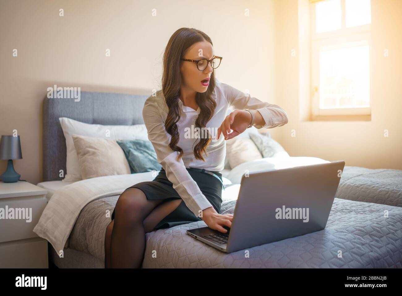 Geschäftsfrau auf Geschäftsreise im Hotelzimmer sitzen und am Laptop arbeiten. Stockfoto