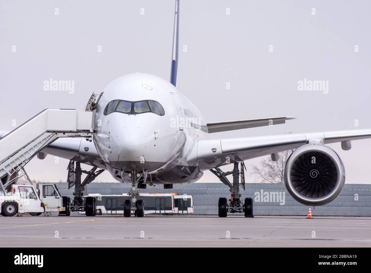 Blick auf ein Langstreckenflugzeug am Flughafen mit einer Rampe auf dem Parkplatz Stockfoto