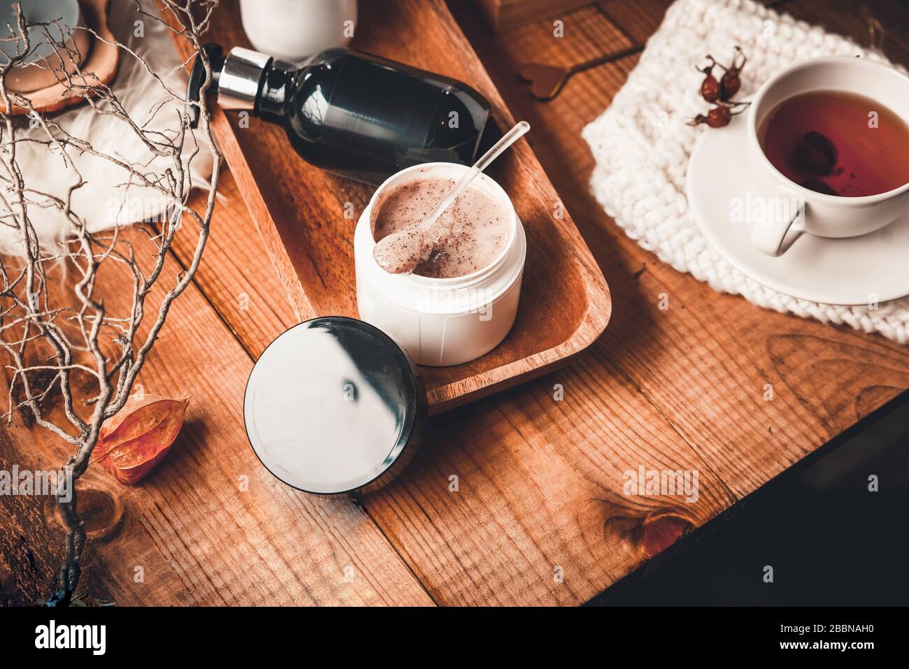 Kosmetikflaschen mit Kosmetik für die Körperpflege auf einem Holztisch. Whirlpool auf Holzgrund. Stockfoto