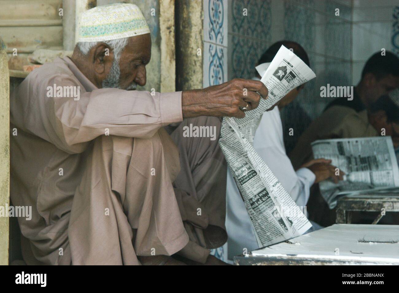 Der alte Mann las die Zeitung Urdu, Karachi, Pakistan Stockfoto