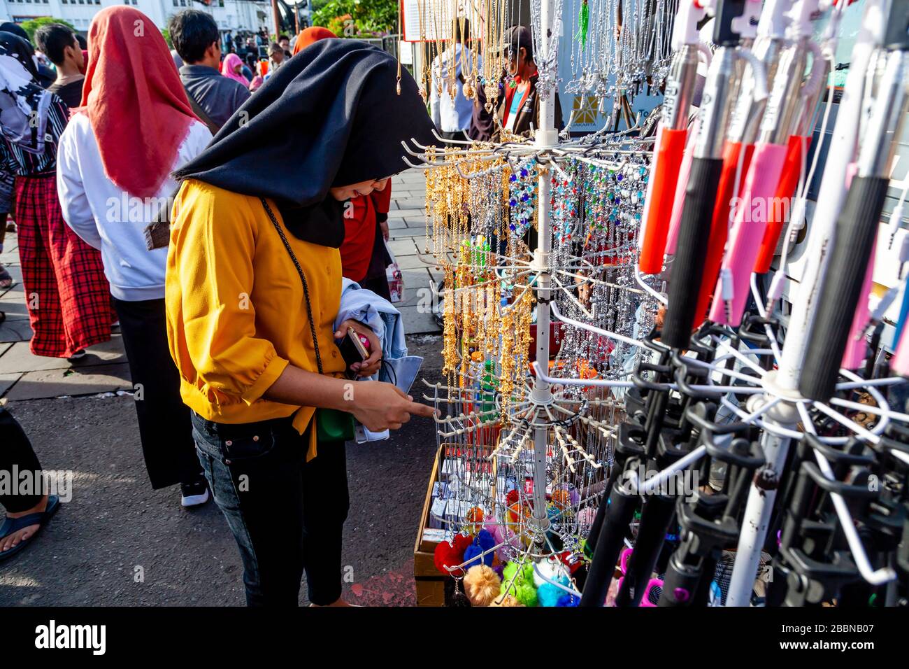 Eine junge Frau betrachtet Schmuck auf EINEM Stall auf EINEM Straßenmarkt im Kota District, Jakarta, Indonesien. Stockfoto