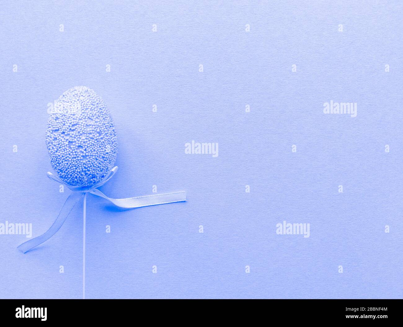 Minimalistisches Oster-Banner in Lavendelfarbe. Flaches Layout mit Kopierbereich. Einzelnes Ei links. Stock-Foto. Stockfoto