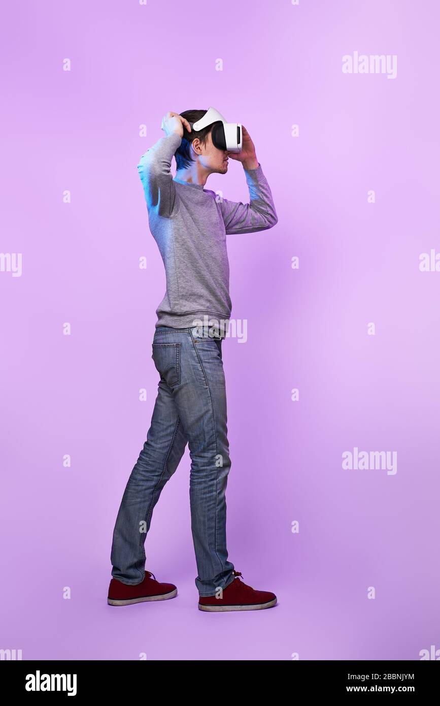 Mann mit Virtual reality Headset. Konzept der virtuellen Realität, Spiele, Unterhaltung und Kommunikation. Bild in der modernen Neon farbe Gamma Stockfoto