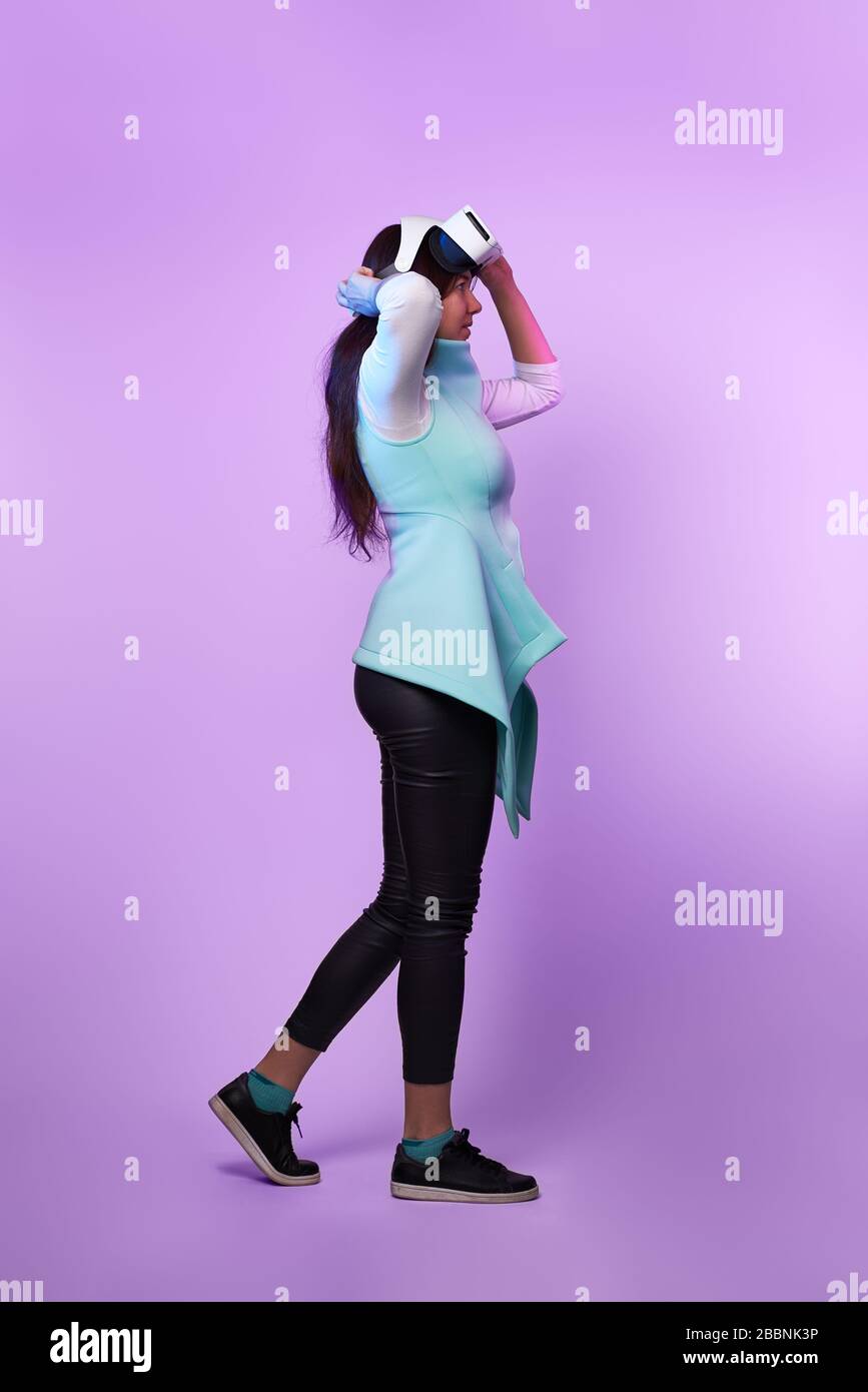 Frau mit Virtual reality Headset. Konzept der virtuellen Realität, Spiele, Unterhaltung und Kommunikation. Bild in der modernen Neon farbe Gamma. Stockfoto