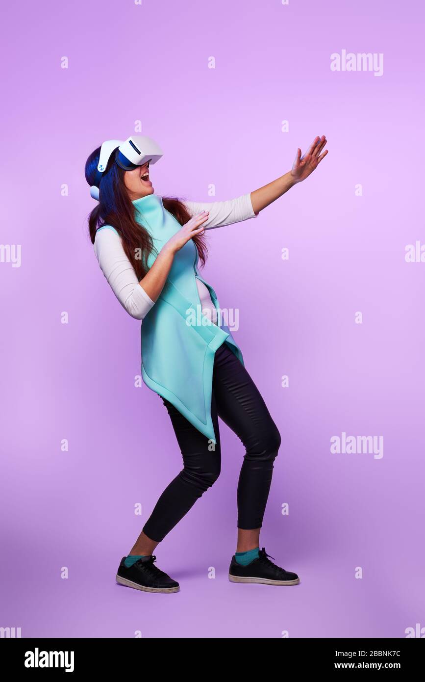 Frau mit Virtual reality Headset. Konzept der virtuellen Realität, Spiele, Unterhaltung und Kommunikation. Bild in der modernen Neon farbe Gamma. Stockfoto