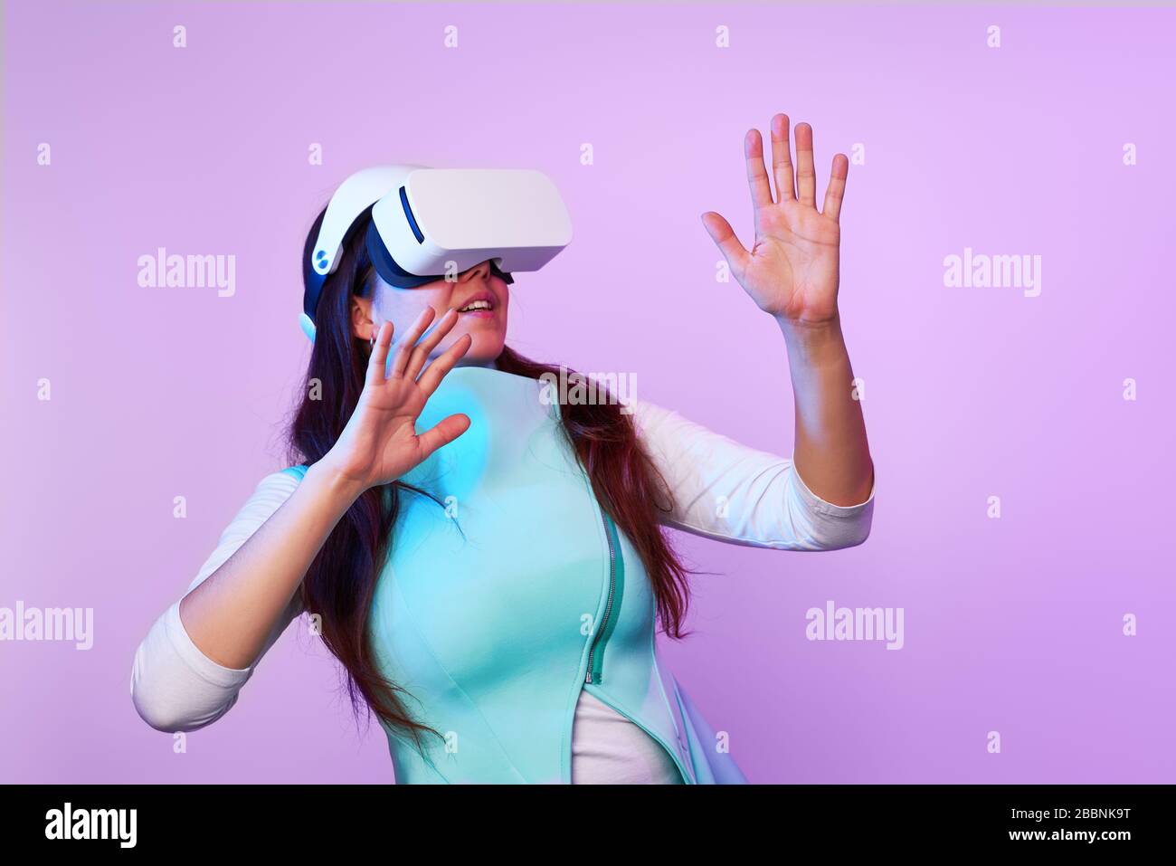 Frau mit Virtual reality Headset. Konzept der virtuellen Realität, Spiele, Unterhaltung und Kommunikation. Bild in der modernen Neon farbe Gamma. Stockfoto
