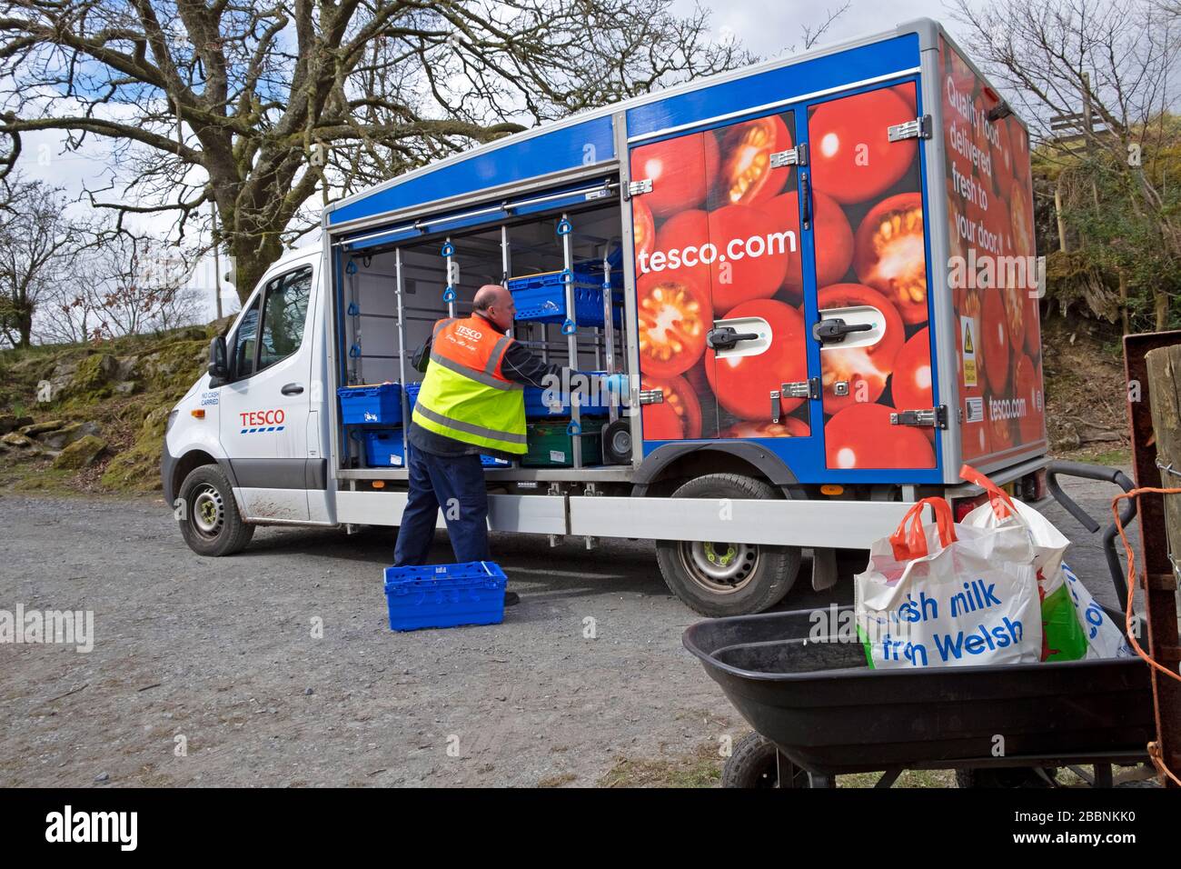 Tesco Supermarkt Lebensmittel Lieferwagen Fahrer Lebensmittelzustellung in Plastiktüten zu einem Kunden zu Hause während der Coronavirus Covid-19 Pandemie Wales UK 2020 Stockfoto