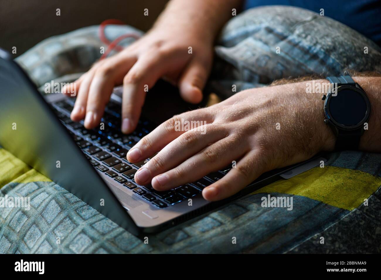 Mann mit Laptop im Home Office. Männliche Hände schreiben auf Tastatur Stockfoto