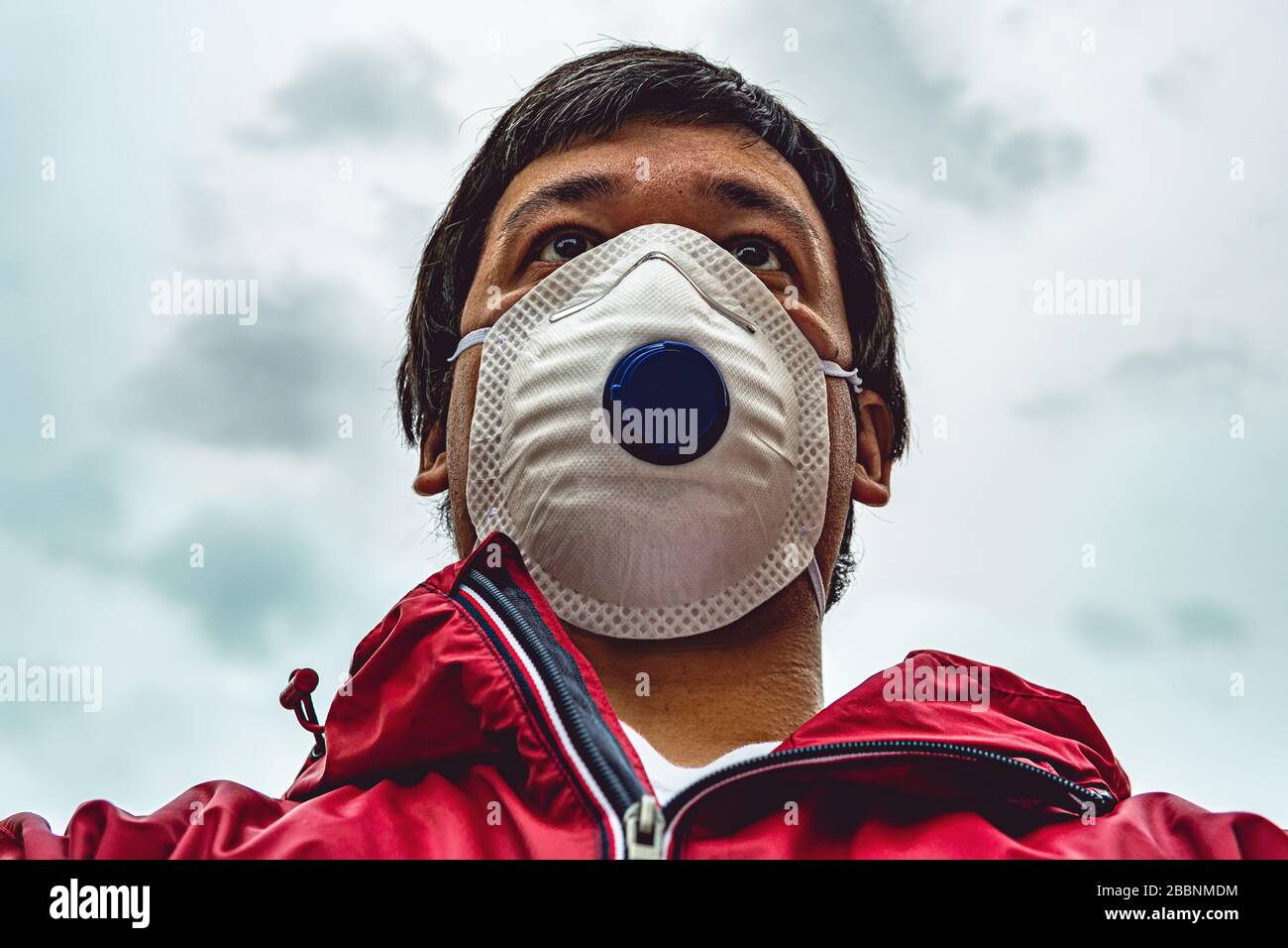Porträt des Menschen in Atemschutzmaske gehen auf der Straße, Ansicht von unten, Verletzung der Quarantäne. Thema der Corona-Virus-Epidemie. Stockfoto