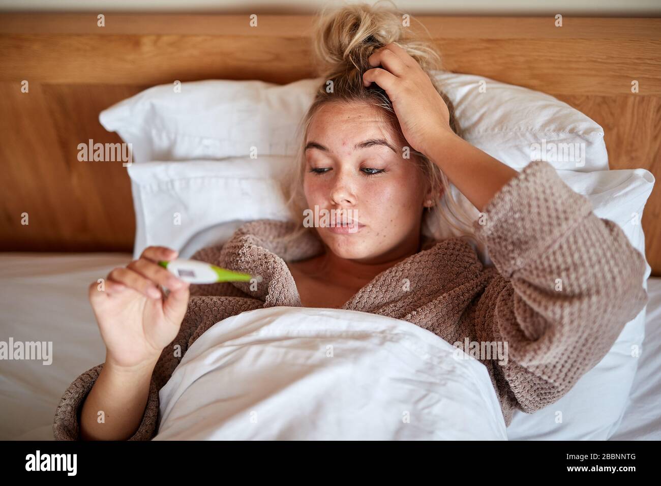 Ein einzelnes, blondes, kaukasisches Weibchen erkrankt im Bett mit einem saisonalen Virus Stockfoto