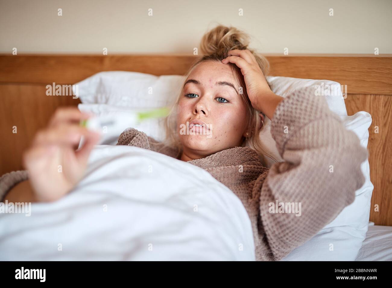 Ein einzelnes, blondes, kaukasisches Weibchen erkrankt im Bett mit einem saisonalen Virus Stockfoto
