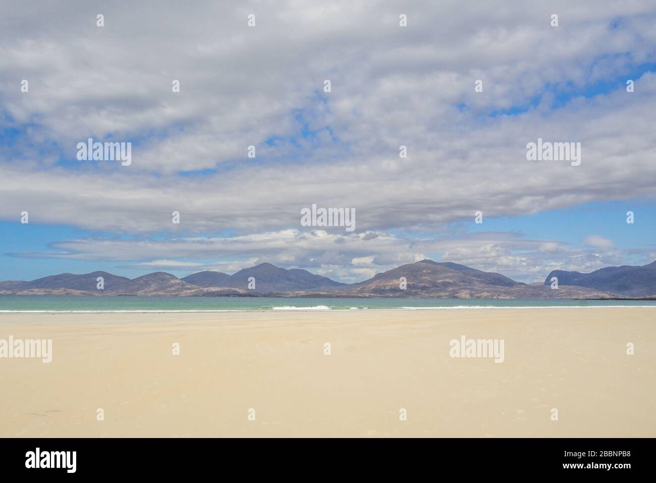 Fantastischer Strand von Luskentire, Insel Harris, Äußere Hebriden, Schottland mit Hügeln von Harris im Hintergrund blauer Himmel und klarem türkisfarbenem Meer Stockfoto