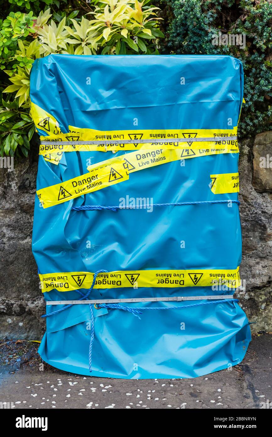 Eine beschädigte Elektroanschlussbox, die mit angewendtem Netzband von Danger Live aus Kunststoff verpackt ist, Schottland, Großbritannien Stockfoto