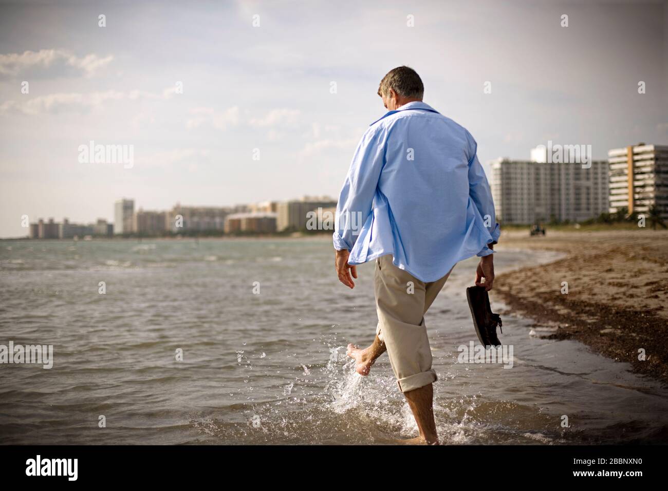 Reifen erwachsenen Mann zu Fuß durch das Meer am Strand. Stockfoto