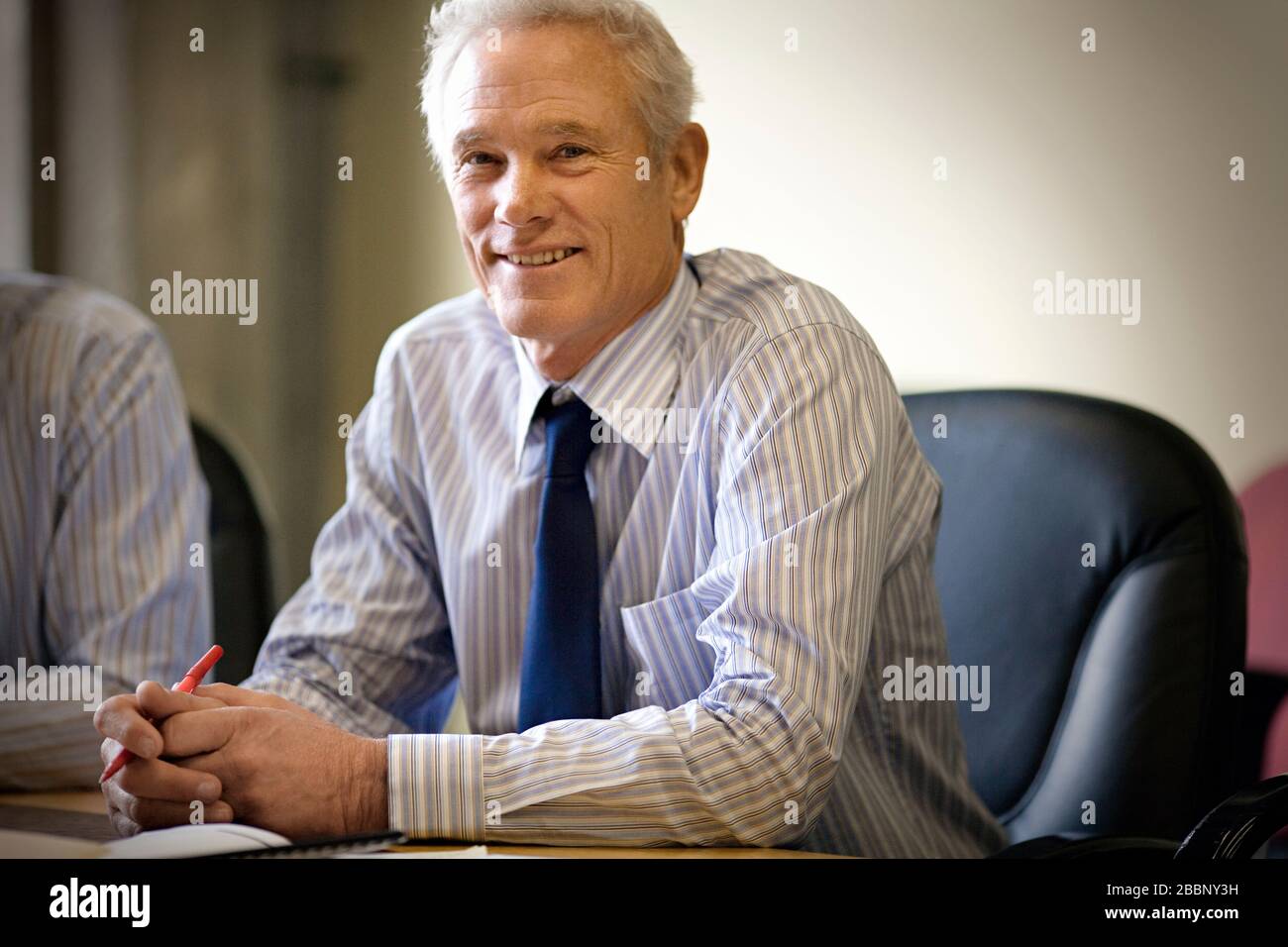 Porträt eines reifen Erwachsenen Geschäftsmann in einem Büro Konferenzraum sitzen. Stockfoto