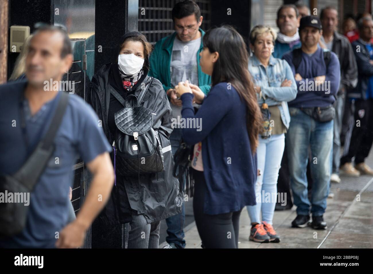 Buenos Aires, Argentinien - 02. April 2020: Nicht identifizierte Menschen, die lange Leitungen zum Essen und zum Einsteigen in Banken in einer unter Quarantäne stehenden Stadt in La Matanza führen Stockfoto