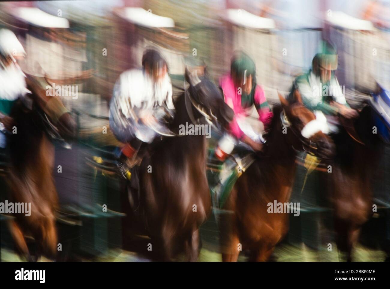 Bewegungsunschärfe von Jockeys auf Pferden scherzt sich für die Position bei der Pause vom Starttor. Stockfoto