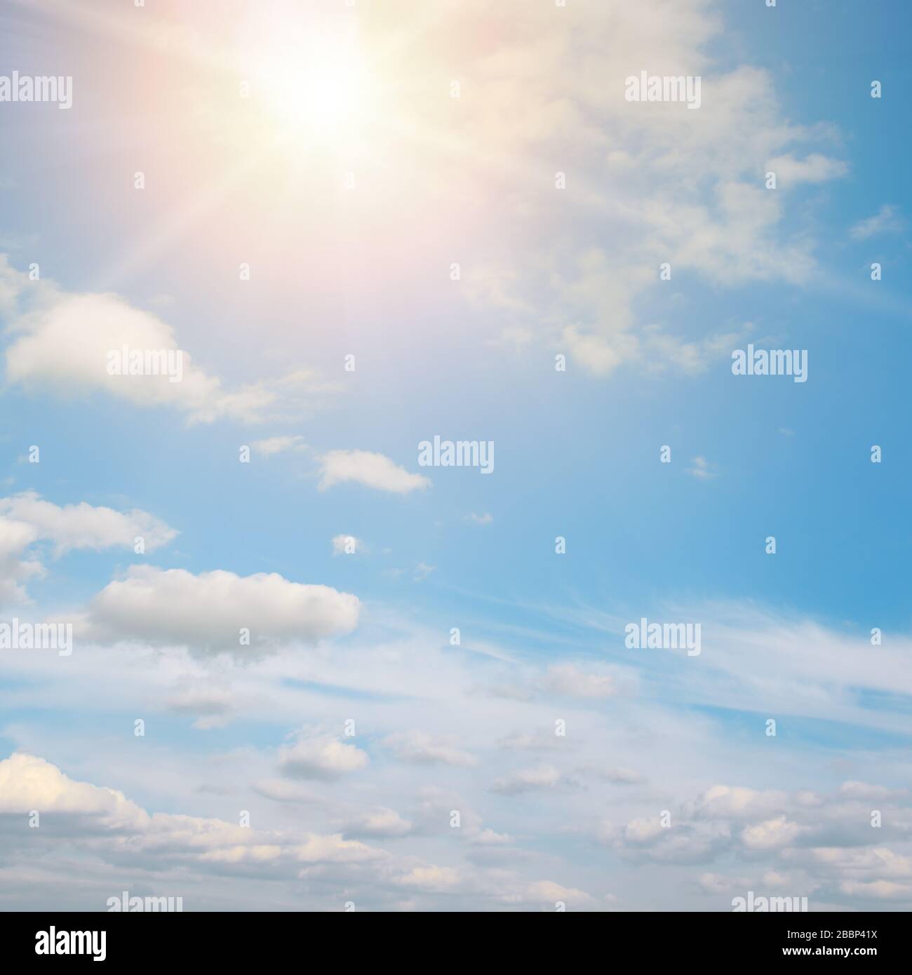 Helle Sonne gegen blauen Himmel und weiße Wolken. Stockfoto