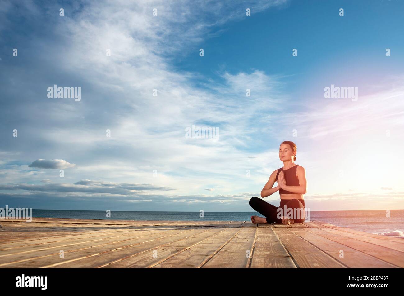 Frau, die morgendliche Meditation in der Natur am Meer praktiziert, gesundes Lebenskonzept. Stockfoto