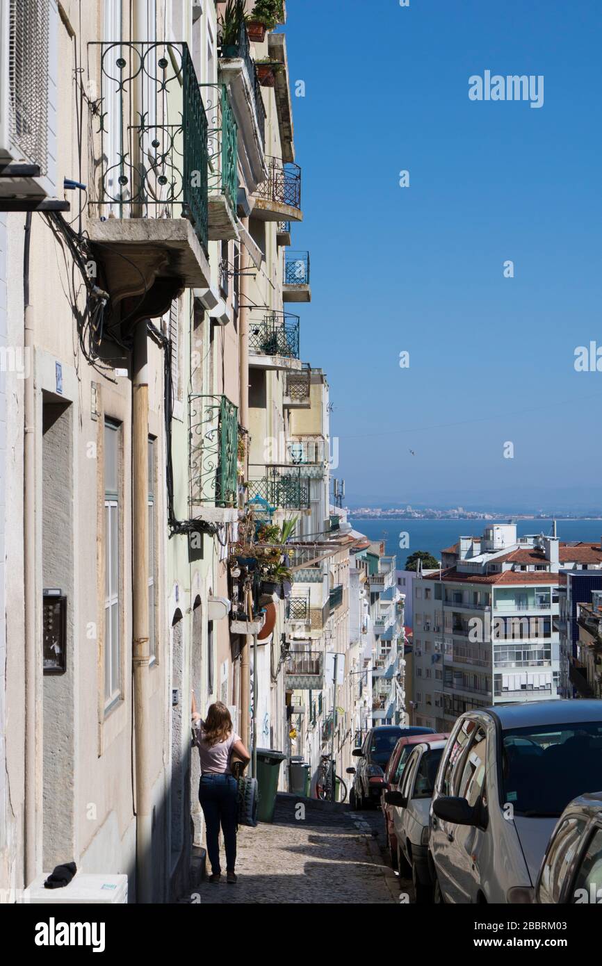 Frau an der Tür. Straße im Zentrum von Lissabon, Portugal. Stockfoto
