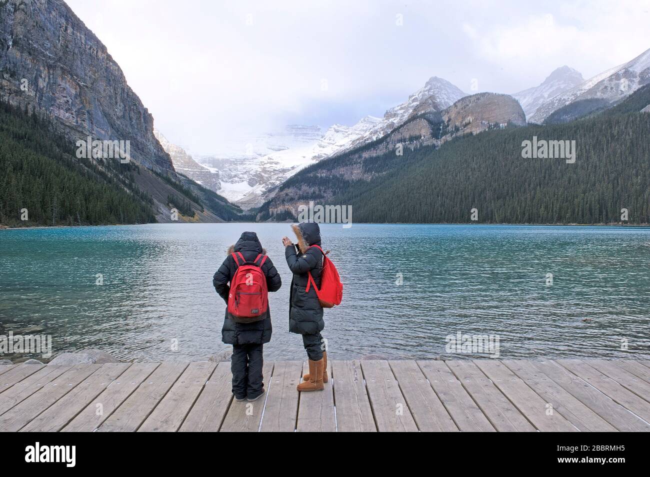 Touristen machen an einem kalten und trüben Tag Fotos in Lake Louise in Banff Stockfoto