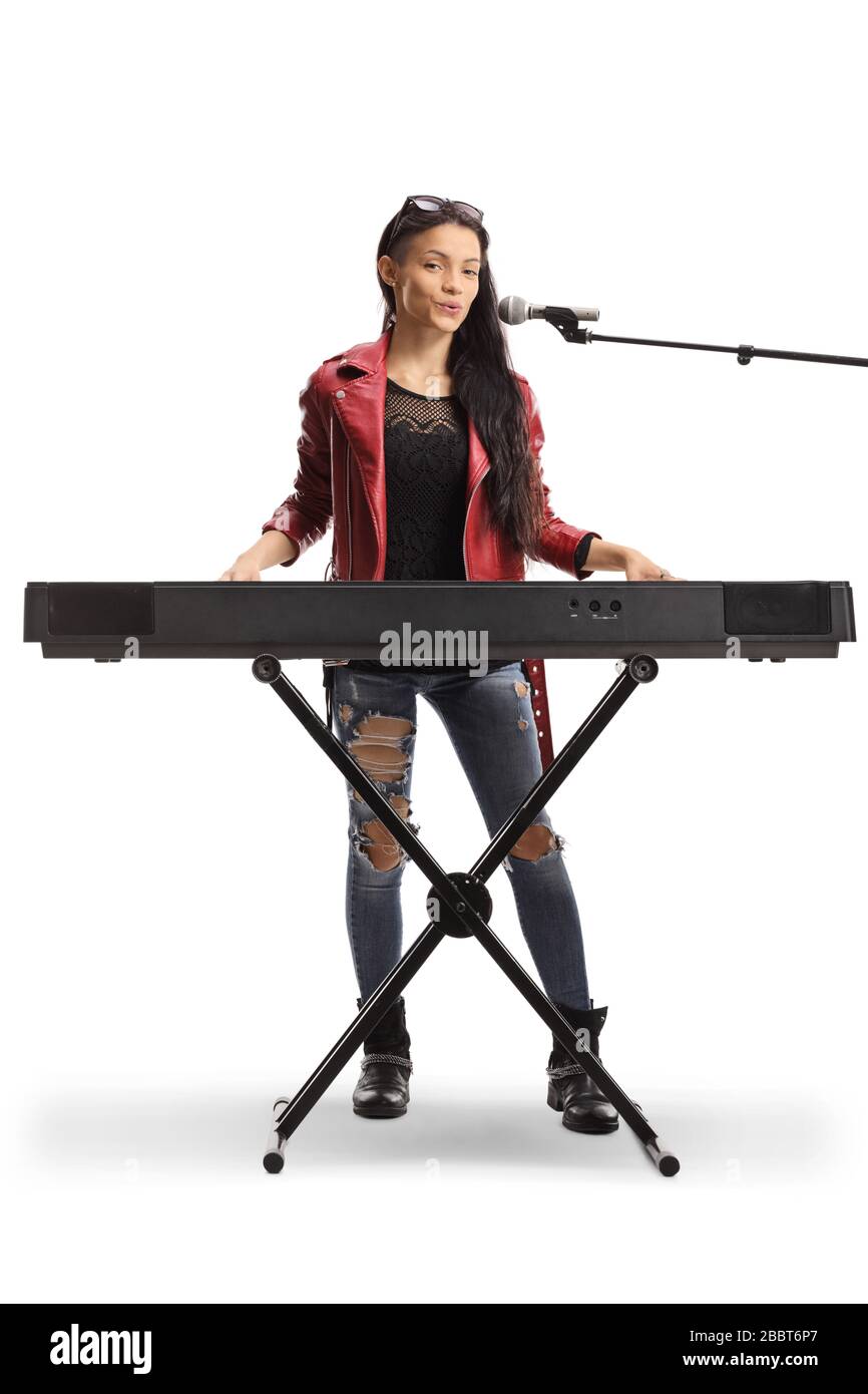 Junge Musikerin spielt eine Tastatur und singt auf einem Mikrofon, das auf weißem Hintergrund isoliert ist Stockfoto