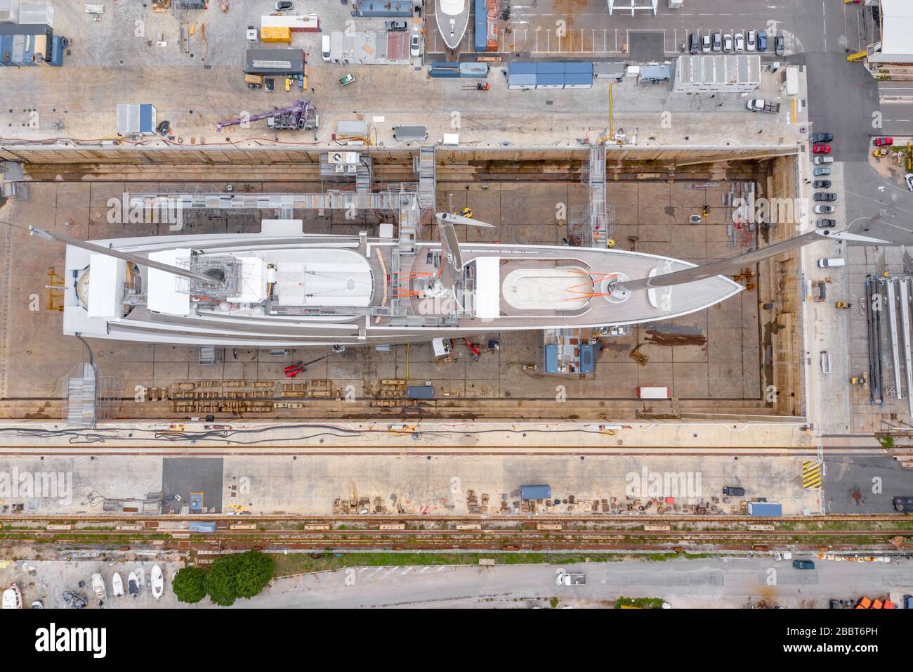Luftaufnahme des Trockendocks in La Ciotat, Frankreich, Frachtkran, Reparaturboote, Luxussegelyacht und Motoryacht, Berg Stockfoto
