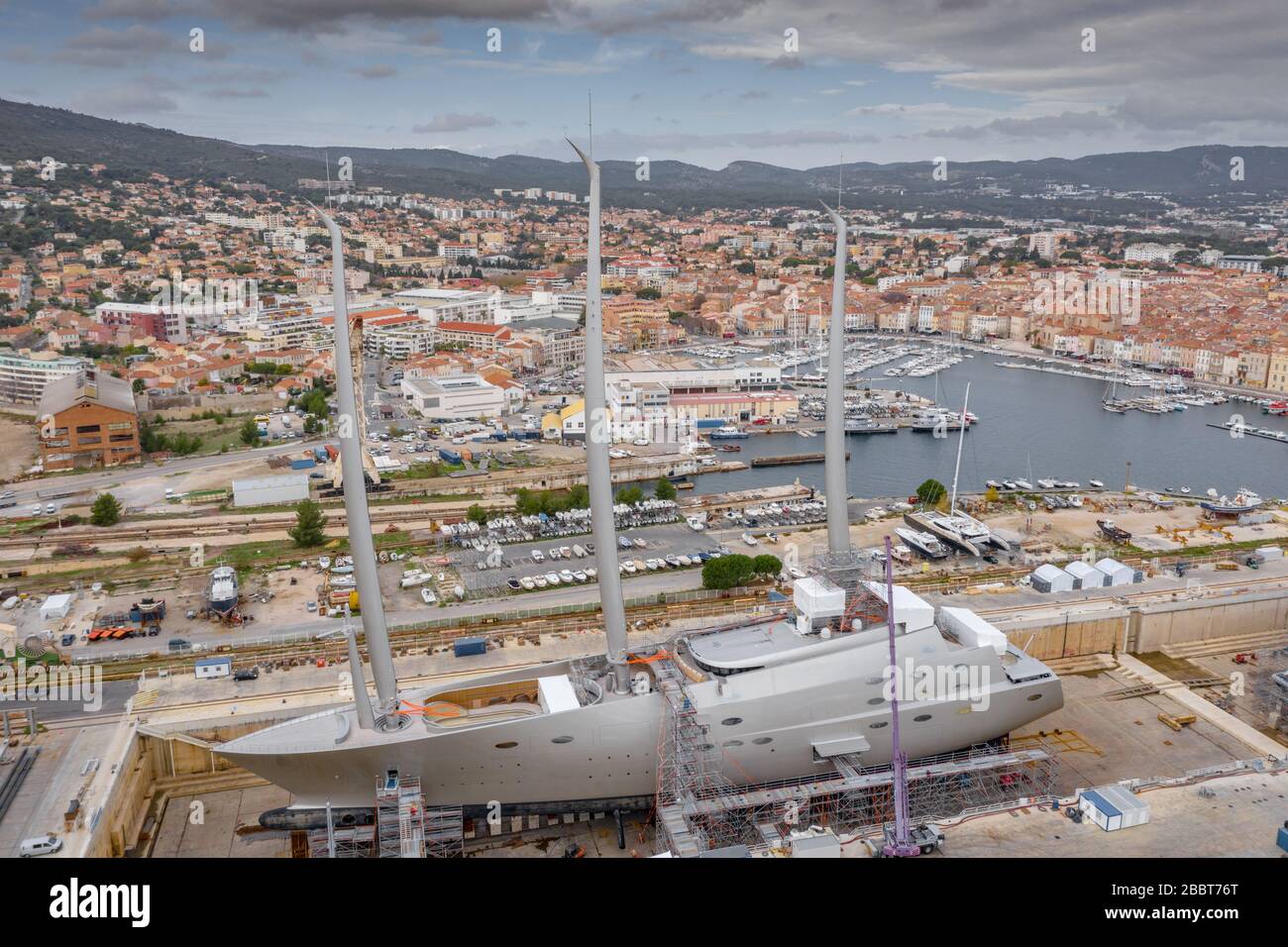 Luftaufnahme des Trockendocks in La Ciotat, Frankreich, Frachtkran, Reparaturboote, Luxussegelyacht und Motoryacht, Berg Stockfoto