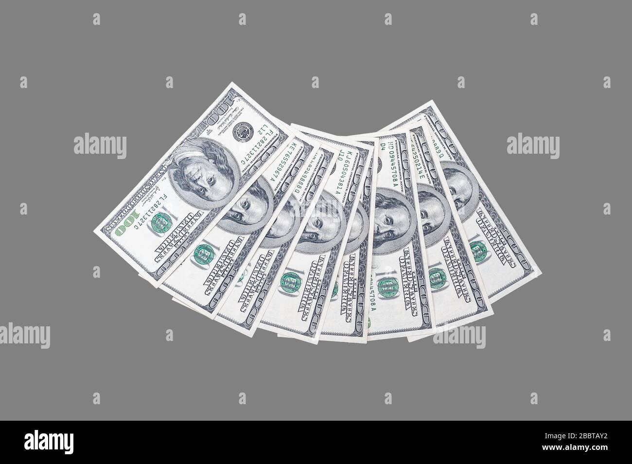 100 US-Dollar-Scheine mit einem Porträt von US-Präsident Benjamin Franklin auf einem isolierten grauen Hintergrund Stockfoto