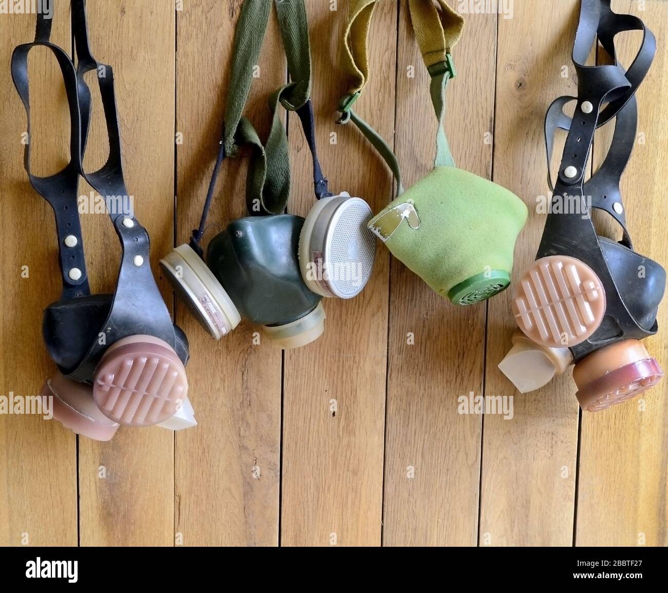 Foto mehrerer Atemschutzmasken im alten Stil auf einem Holzwandhintergrund Stockfoto