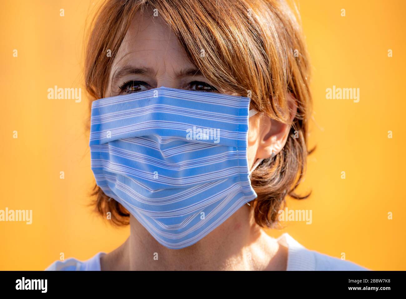 Frau, die eine Atemmaske trägt, selbstgenäht, aus Baumwolle, Auswirkungen der Koronakrise in Deutschland, Stockfoto