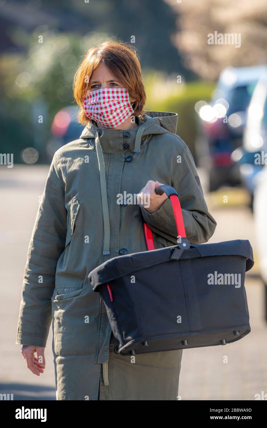Frau geht einkaufen, trägt eine Atemmaske, selbstgenäht, aus Baumwolle, Auswirkungen der Koronakrise in Deutschland Stockfoto