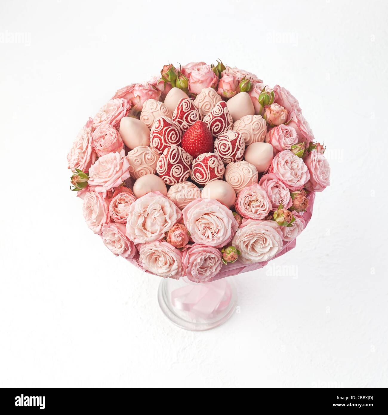 Blumenstrauß aus Rosen und Erdbeeren, bedeckt mit rosafarbener Schokolade  auf weißem Grund Stockfotografie - Alamy