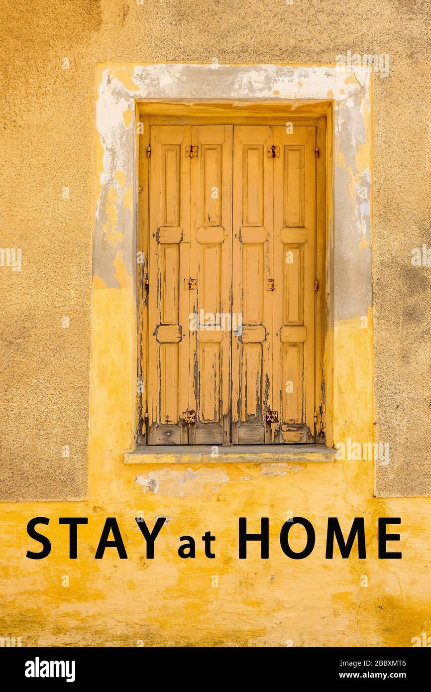 Sperrregeln. Hintergrund für Sperrung zu Hause. Einschränkungen beim Verlassen Ihres Hauses. Geschlossene alte Blenden an blasser gelber Wand. Pandemische Regierung verschärft Stockfoto