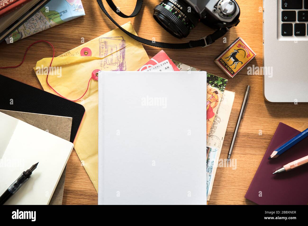 Ein Buch auf dem Schreibtisch mit Reiseplanungsartikeln Stockfoto