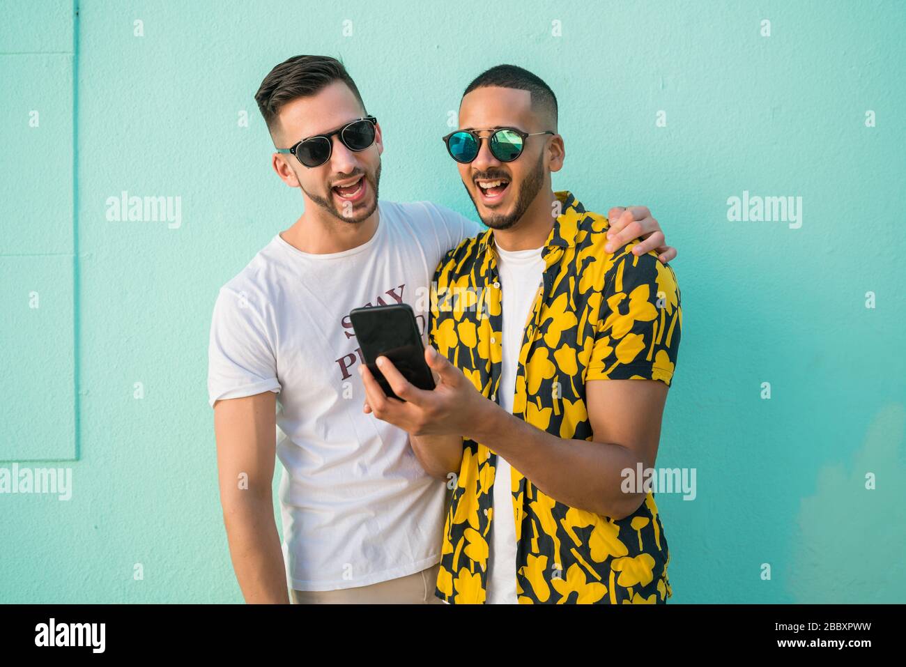 Portrait von Happy homosexuelles Paar Zeit miteinander zu verbringen, während über Handy. Lgbt und liebe Konzept. Stockfoto