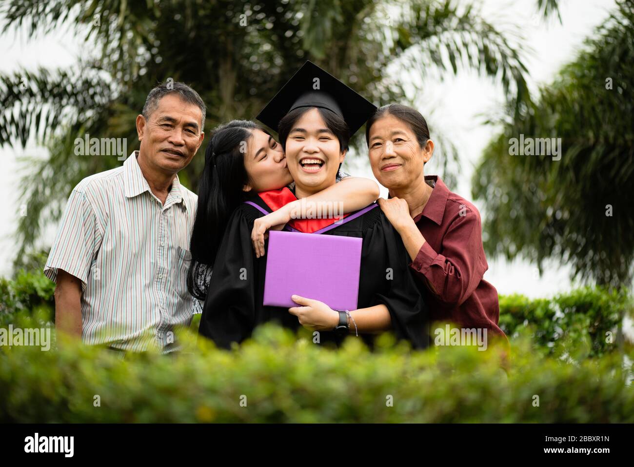 Abschlussfeier. Eltern und Familie gratulieren dem Studenten, der sein Studium an der Universität beendet hat. Stockfoto