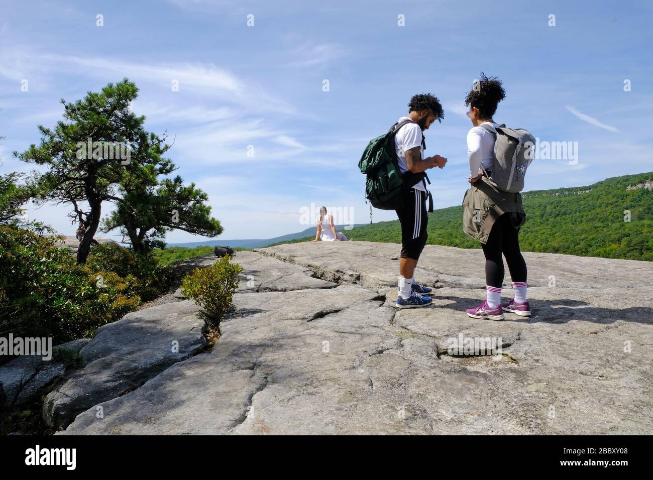 Junge Erwachsene, die im Minnewaska State Park Preserve, Mohonk Preserve, Gertüde's Nose, dem Grat, Felsformationen in den Shawangunks wandern. Hudson Valley Stockfoto