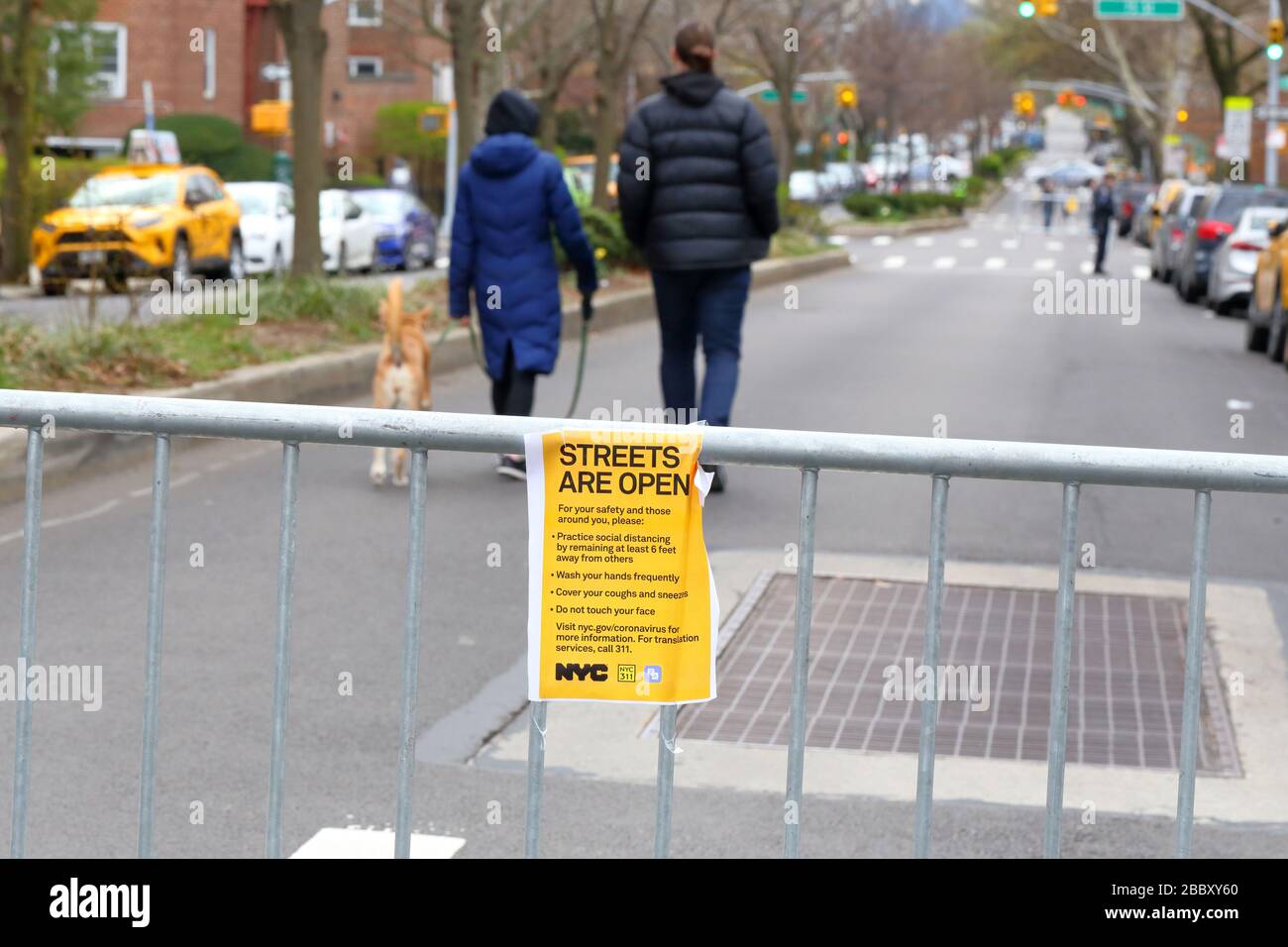 New York, New York, 31. März 2020. Ein Paar und ein Hund gehen eine Straße hinunter, die für den Fahrzeugverkehr in Jackson Heights gesperrt ist... WEITERE INFORMATIONEN ZUR VOLLSTÄNDIGEN BESCHRIFTUNG FINDEN SIE UNTER Stockfoto
