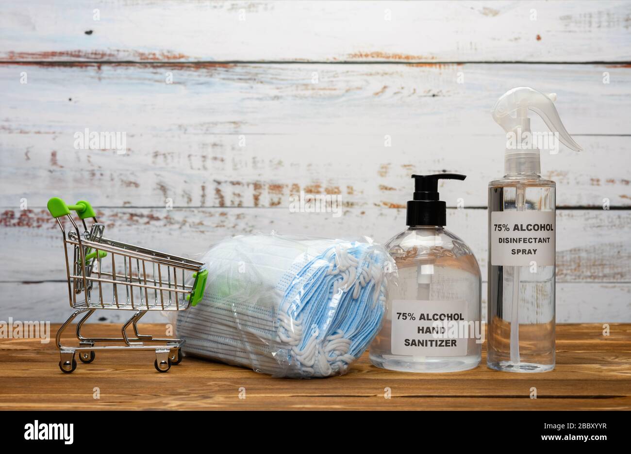 Einkaufswagen mit medizinischen Masken und Handdesinfektionsmittel und Alkoholdesinfektionsspray Konzept des Kaufens von Sachen gegen den COVID-19 Stockfoto