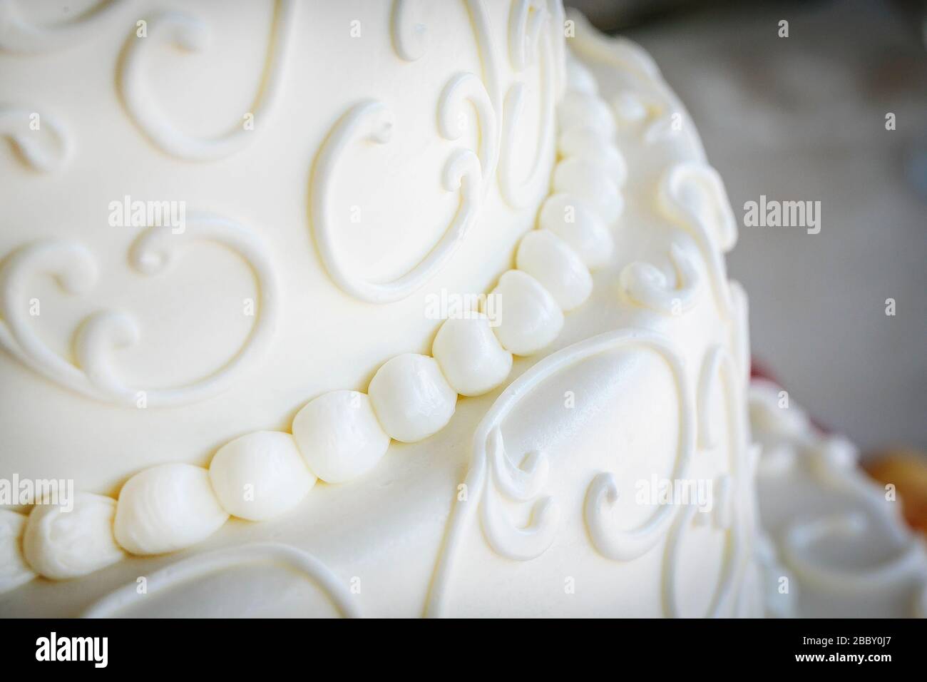 Weiße Fondanteise mit dekorativen Wirbeln auf einem Hochzeitstorte Stockfoto