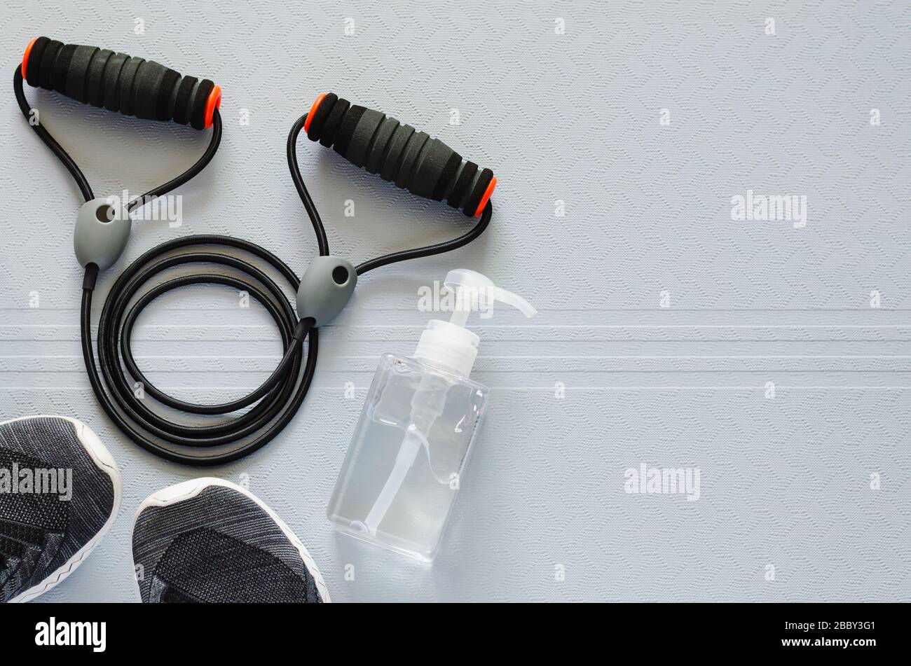 Eine Flasche Alkoholgel zum Reinigen der Hand nach dem Gebrauch von Sportgeräten für den häuslichen Aufenthalt, um Infizierte vor Corona viru zu schützen Stockfoto